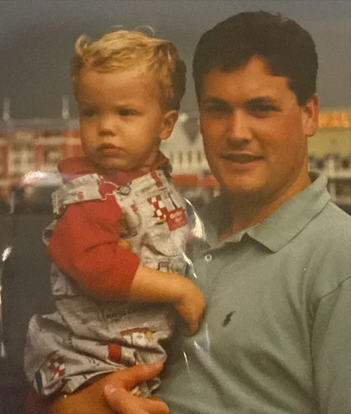 Nate Walters holding his young son Tyler outdoors at night in 1995